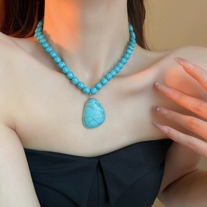 Close-up of bohemian turquoise beaded necklace with a large cracked teardrop pendant