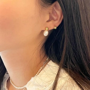 Detail of S925 silver freshwater pearl drop earrings and matching necklace on a model
