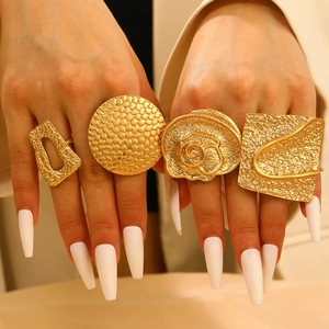 Chunky gold punk geometric rings set with hammered texture on female model hand