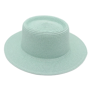 Detailed weave texture of the mint green straw hat with a flat top and wide brim