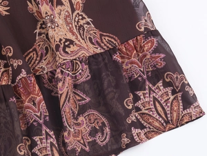 Detailed view of bohemian paisley print on chiffon dress with ruffled hem and floral patterns