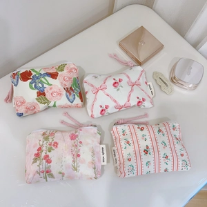 Flat lay of pink floral cotton mini pouches with ribbons and zippers for cosmetics