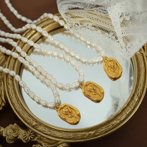 French vintage freshwater pearl necklace with gold rose relief pendant on mirror