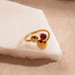 Vista dettagliata dell'anello placcato oro con sfera di zircone rosso e finitura lucida