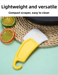 Close-up of yellow silicone kitchen scraper tool for cleaning plates and pans easily