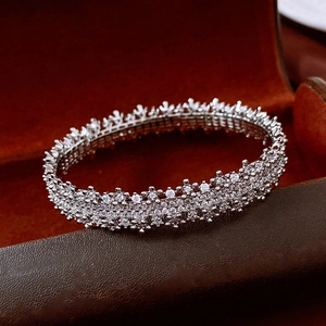 Macro shot of silver paved cubic zirconia bangle inside a red velvet jewelry box