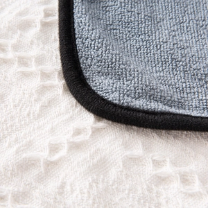 Close-up of blue microfiber pet towel showing thick coral fleece texture and black stitching