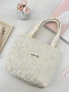 Quilted canvas tote bag with colorful floral embroidery and soft handles for daily commute