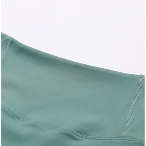 Close-up of grey-green yoga shorts showing high-quality flatlock stitching and soft texture