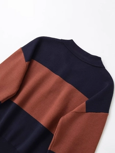 Close-up of crew neck knit sweater featuring navy and caramel color block stitching