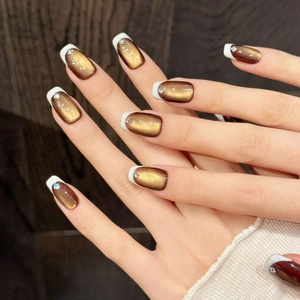 Faux ongles œil-de-chat dégradé marron avec pointes French blanches et strass