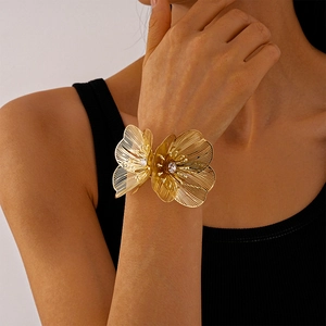 Détail du bracelet manchette floral doré avec strass étincelants sur poignet féminin