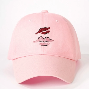 Pink cotton baseball cap with embroidered lip pattern on a white background