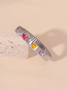 Close-up of titanium steel bracelet featuring colorful acrylic stones on stone texture