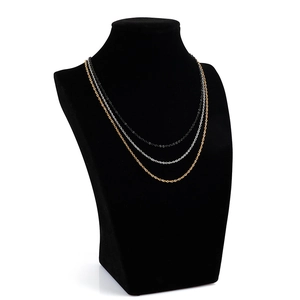 Detailed view of triple-layered gold, silver and black steel O-chains on a velvet display