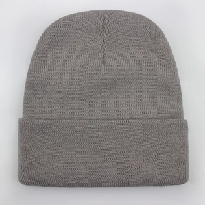 Close-up of gray knitted beanie showing fine texture and warm folded ribbed cuff detail