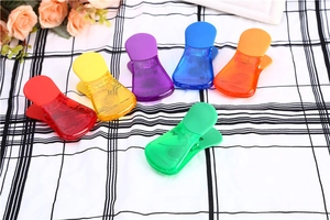 Clip per snack trasparenti colorate multifunzione su sfondo di tessuto a quadretti