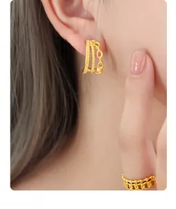 Detail of 18K gold plated triple layered C-shaped hoop earrings and textured chain ring