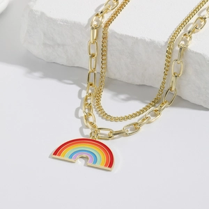 Detailed macro shot of a golden double-layered chain necklace with a rainbow enamel pendant