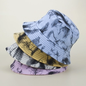 Detailed stack of tie-dye bucket hats in blue, yellow, white, and purple with black prints