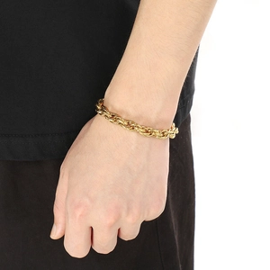Detail of twisted Cuban chain bracelet in 18k gold plating worn on wrist for men and women