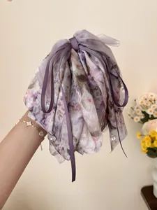 Dettaglio della pinza per capelli in chiffon floreale con nastri e cristalli