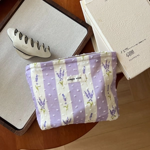 Detail der floralen Kosmetiktasche mit Lavendeldruck und schlichter cremefarbener Haarklammer