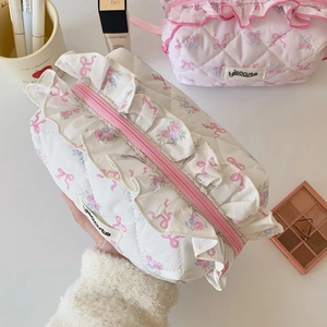 Quilted floral ribbon cosmetic bag with ruffled edges in white and pink color