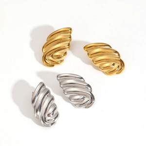 Detailed close-up of 18k gold and silver wing-shaped textured stainless steel stud earrings