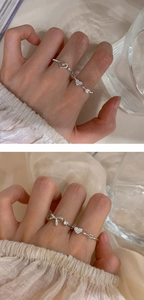 Close-up of sparkling heart and bow silver rings set for women in minimalist style