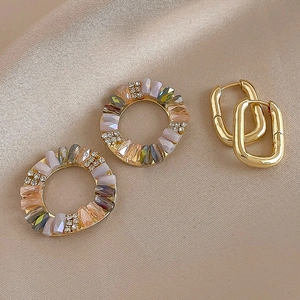 Vintage gold hoop earrings with multi-colored stones and a minimalist oval buckle design