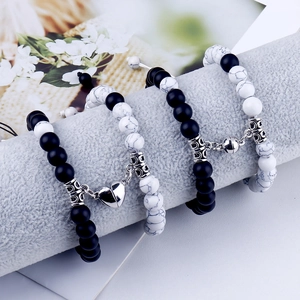Detail of couple's magnetic bracelets with heart magnets and black matte stone beads