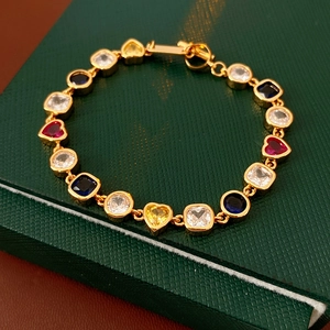 Gros plan de pierres précieuses multicolores en cœur et carrées sur un bracelet vintage doré
