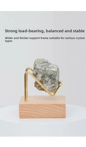 Detailed close-up of a sturdy brass mineral display stand with a walnut wood base