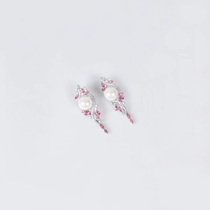 Detailed view of silver drop earrings with white pearls and pink marquise crystals
