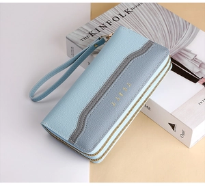 Detail of light blue lychee pattern faux leather wallet with gold double zippers and wristlet