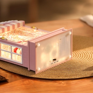 Detail view of pink Christmas music box base with battery compartment and power switch