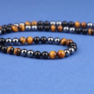 Macro-opname van 8mm tijgeroog en obsidiaan kralen met natuurlijke glans en textuur