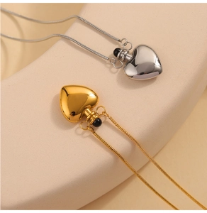 Detail of heart-shaped memorial pendant necklaces in gold and silver with snake chains