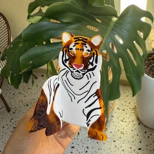Detail of creative tiger-shaped acetate hair claw clip with orange and black stripes