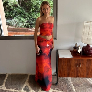Détail d'un ensemble crop top et jupe longue à imprimé floral rouge et orange sur modèle
