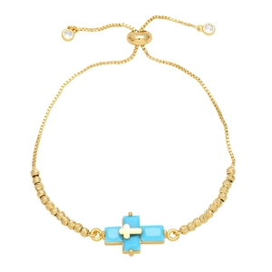 Detailed close-up of a gold double-layer cross bracelet with turquoise inlay and adjustable slider