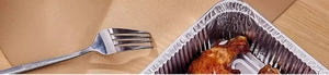 Detailed close-up of a food-grade aluminum foil container with roasted chicken and a fork