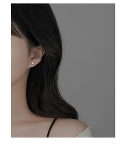 Close-up of S925 sterling silver earring with cubic zirconia worn by a model