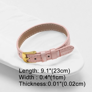 Detailed view of pink crocodile pattern leather strap with gold buckle and size markings