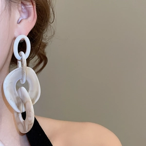 Close-up of model wearing white and beige marble acrylic chain link drop earrings