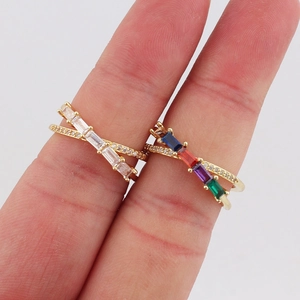 Detail of gold-plated crossover rings set with colorful rectangular zircons and pavé accents