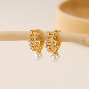 Detail of gold-plated hoop earrings with double-row zircon and hanging white pearls