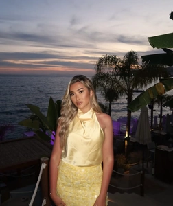 Détail du haut dos nu en satin jaune et jupe à paillettes assortie à la plage