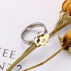 Macro view of flower ring with silver petals, gold accents and a sparkling central diamond